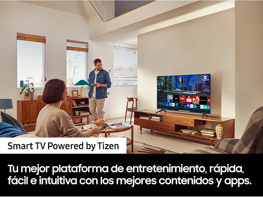 Una pareja en una sala de estar con un televisor que muestra un programa de noticias.