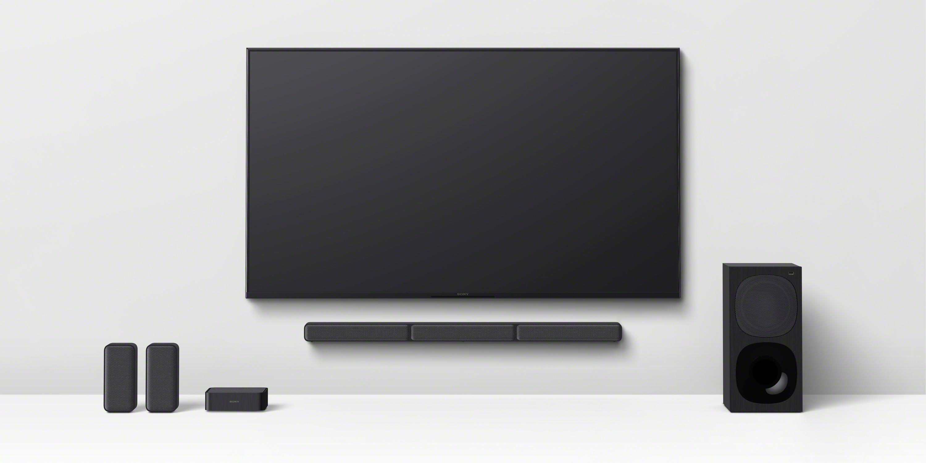 Ein Fernsehgerät mit Soundbar, Subwoofer und zwei Satellitenlautsprechern.