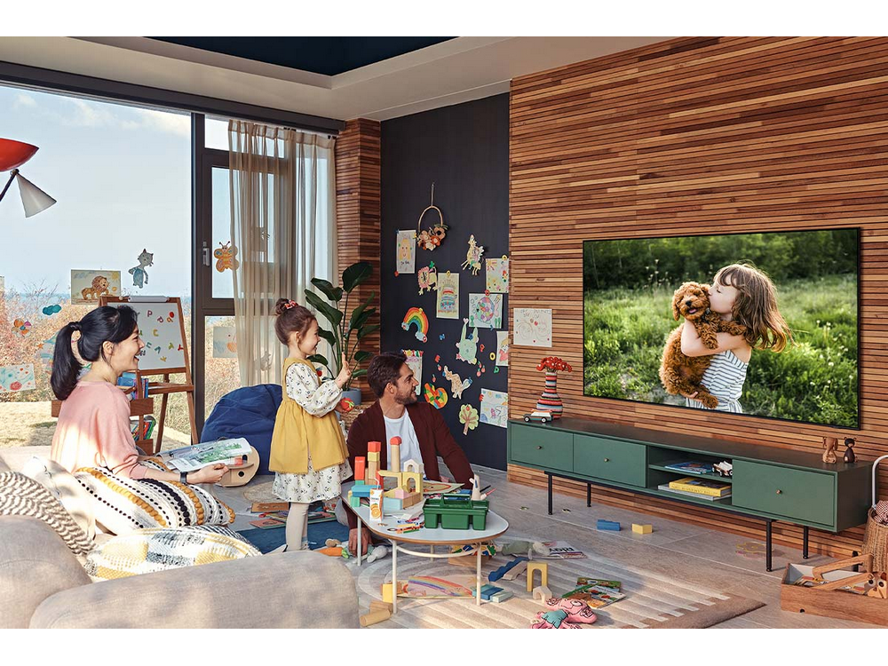 Familia en sala de estar viendo TV con niño y perro.
