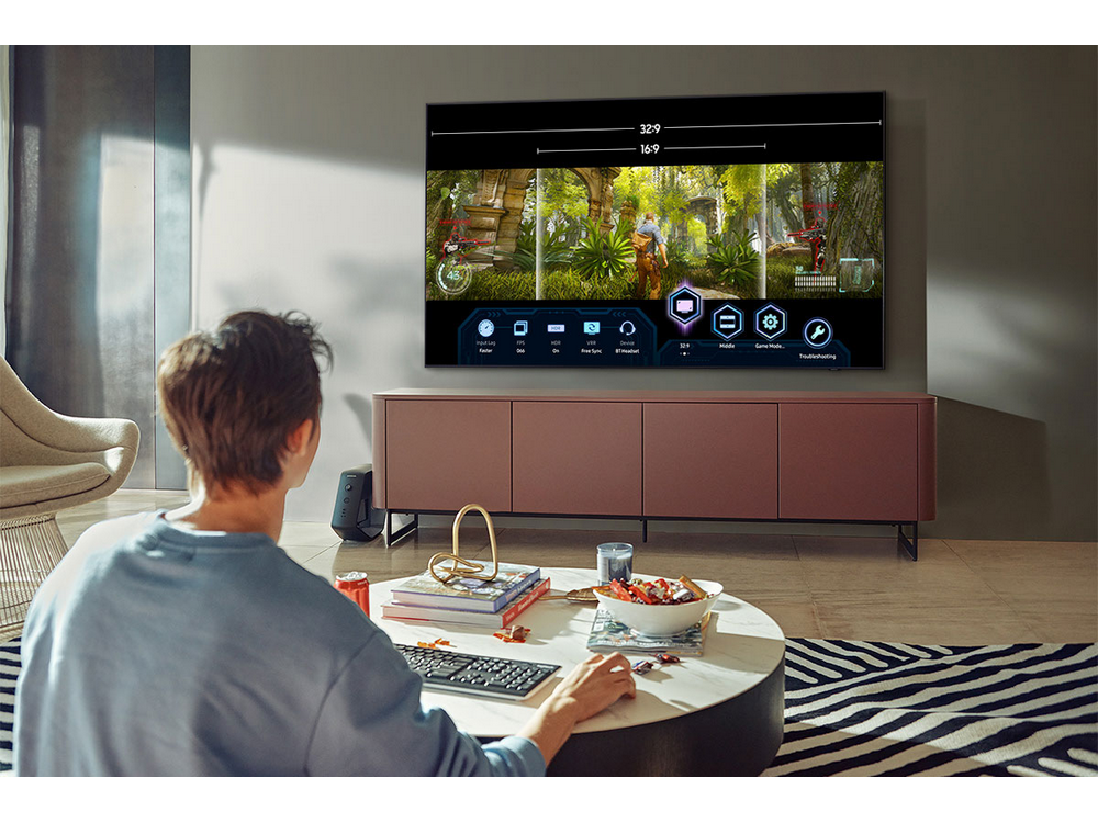 Persona viendo un televisor con un videojuego, con una mesa de centro y muebles de consola.