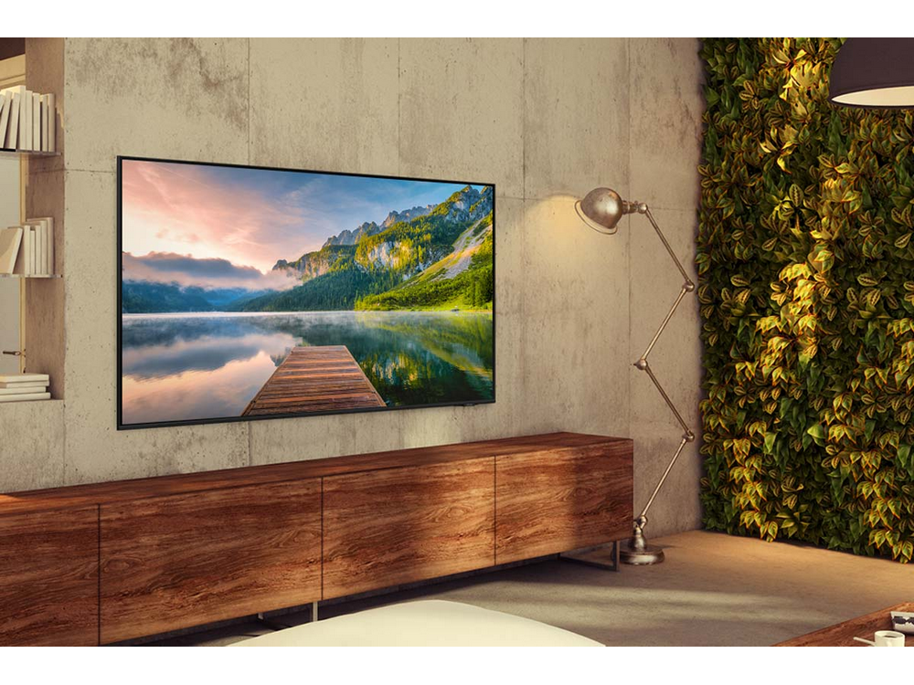 Una sala de estar moderna con un televisor en la pared, un sofá y una lámpara de pie.
