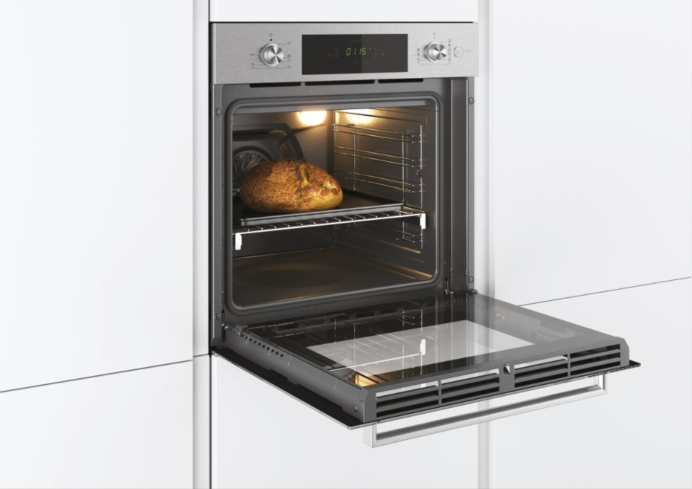 Horno abierto con pan en una rejilla. El entorno es blanco.