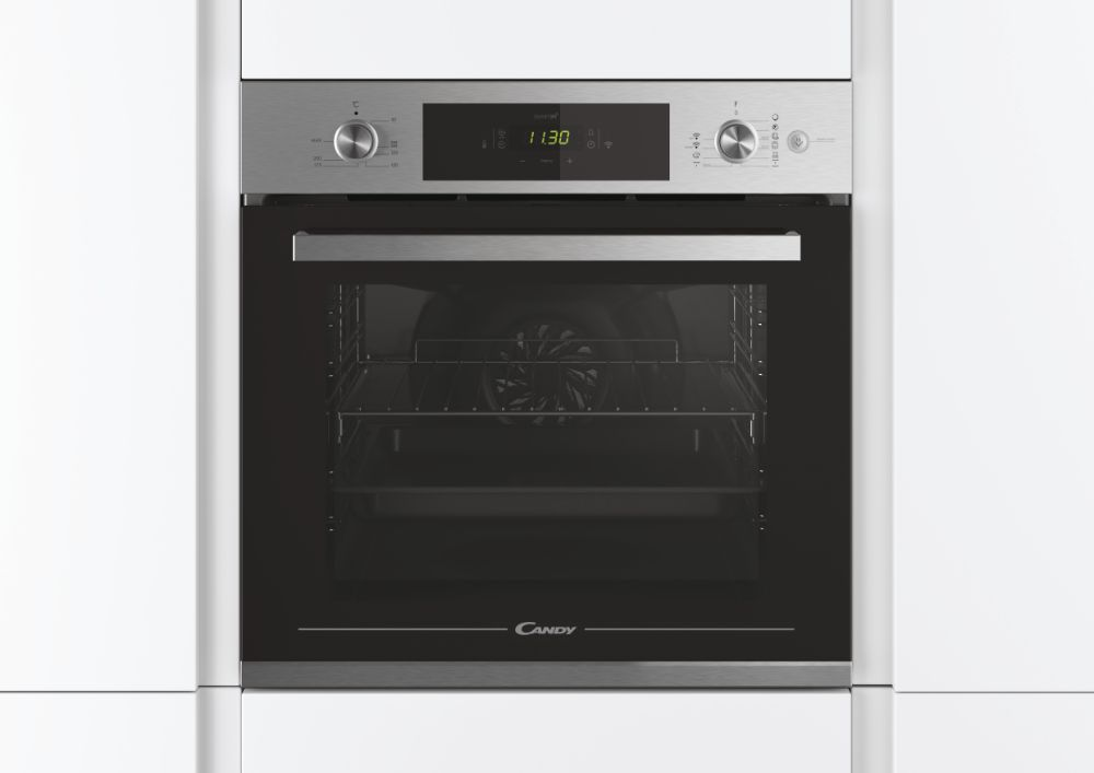 Horno empotrado en armarios blancos. Pantalla digital mostrando la hora. Marca Candy.