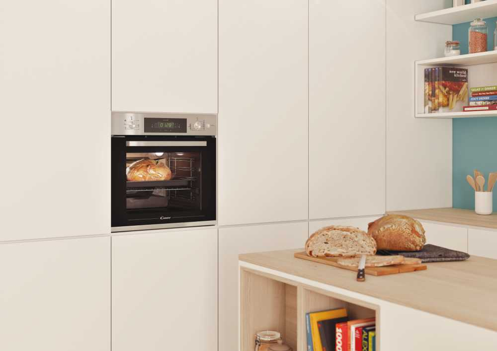 Un horno empotrado en un armario de cocina blanco con pan dentro.
