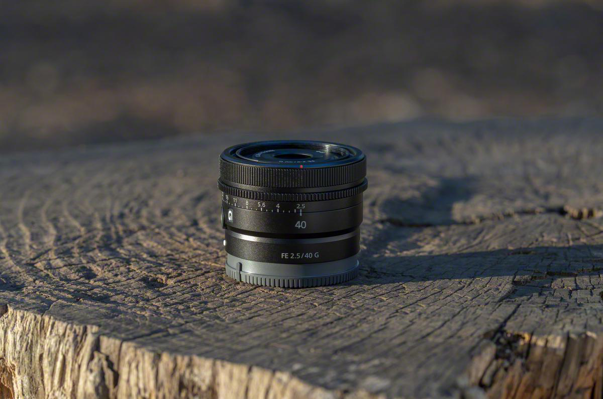 Schwarzes Kameraobjektiv auf Holz. Markiert mit 40 und FE 2.5/40 G.
