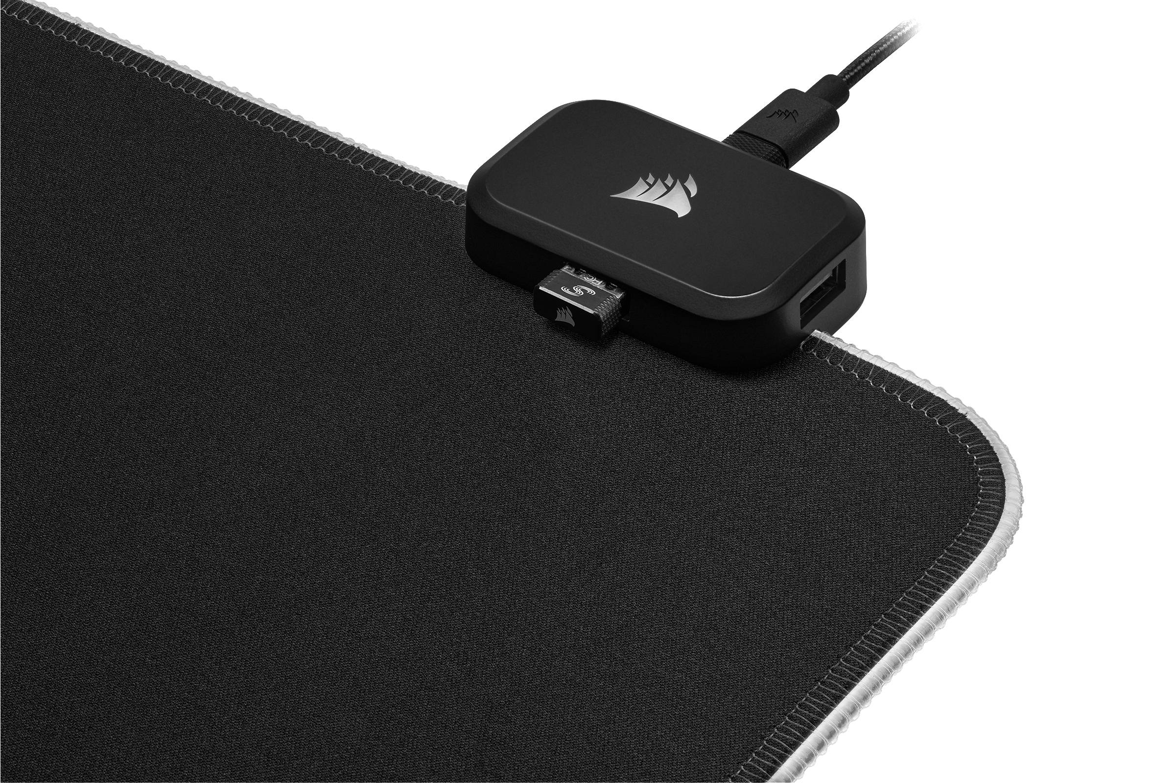 Schwarzes Mauspad mit schwarzem Controller und USB-Kabel. Weißer Hintergrund.