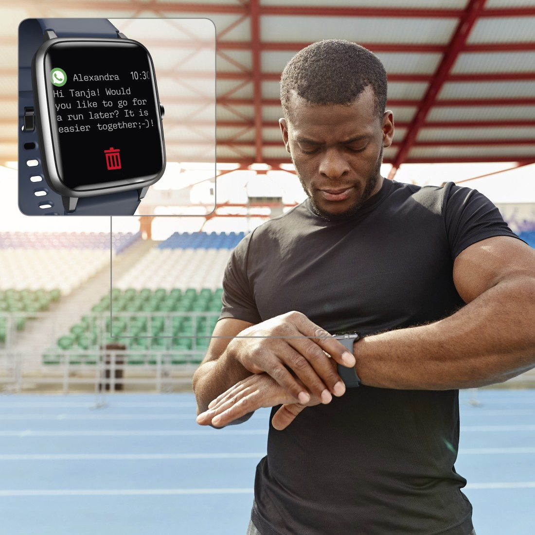 Mann betrachtet Smartwatch mit Nachricht, auf Stadionhintergrund.