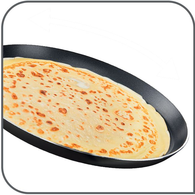 Crêpe in einer schwarzen Pfanne. Die Pfanne ist leicht gekippt, weißer Hintergrund.