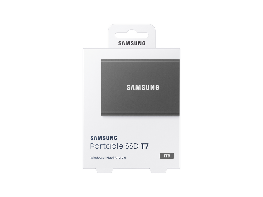 Un SSD portátil Samsung T7 en su embalaje, caja blanca con SSD gris.