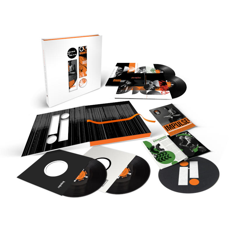 Coffret vinyle avec disques, livrets et encarts, avec graphiques noirs et oranges, sur une surface blanche.