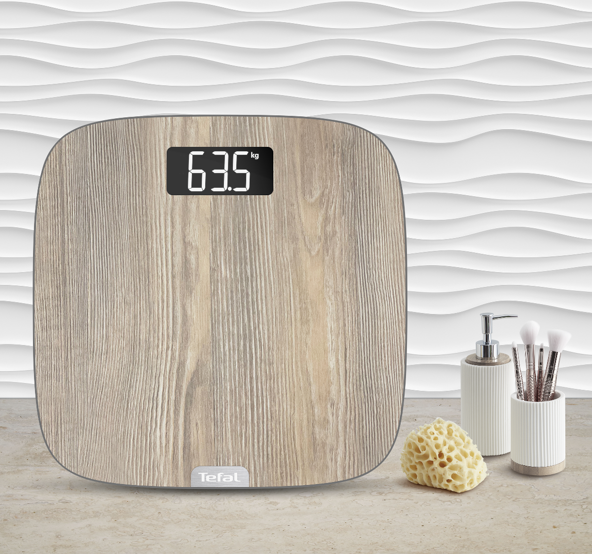 Een digitale weegschaal toont 63,5 kg. Daarnaast een zeepdispenser, borstels en een spons op een licht oppervlak.
