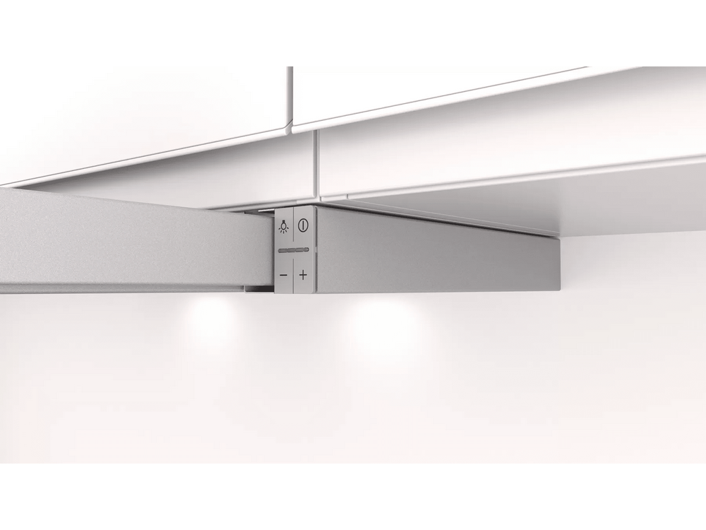 Primer plano de una luminaria de cocina con controles. Es plateada y está montada debajo de un armario.