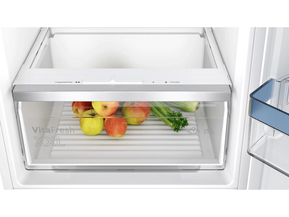 Refrigerador con un cajón transparente lleno de manzanas rojas y amarillas, y apio.