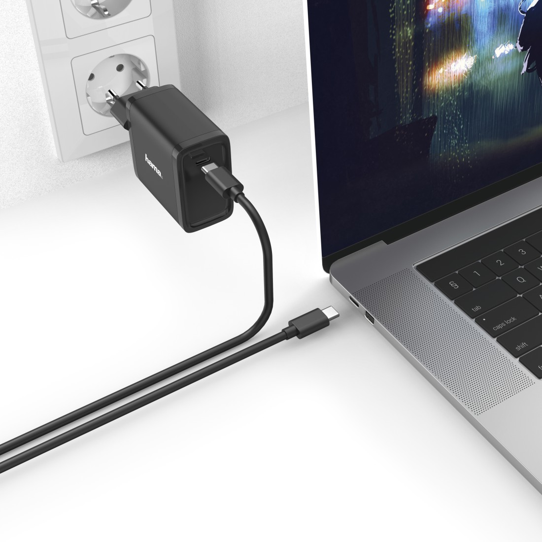 Schwarzes Hama-Ladegerät, das an eine Steckdose und einen Laptop angeschlossen ist.