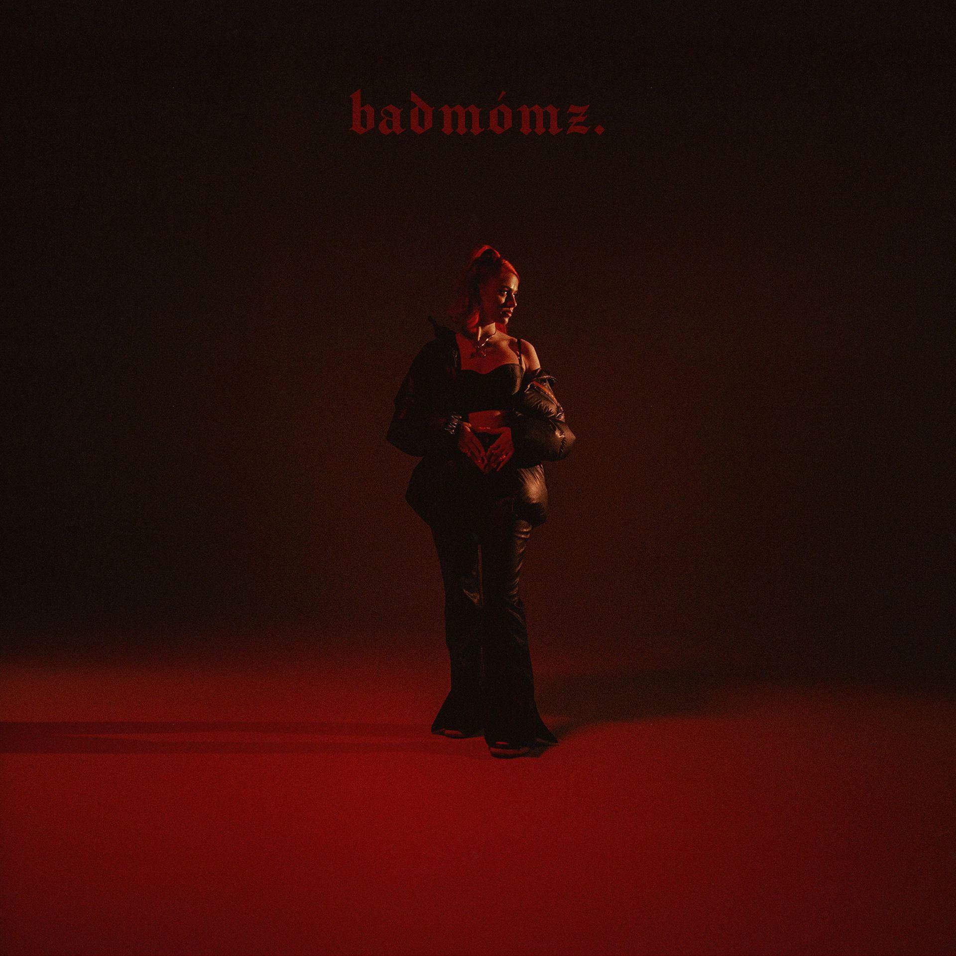 Albumcover: Frau in Schwarz, steht in rotem Licht. Titel: badmómz.