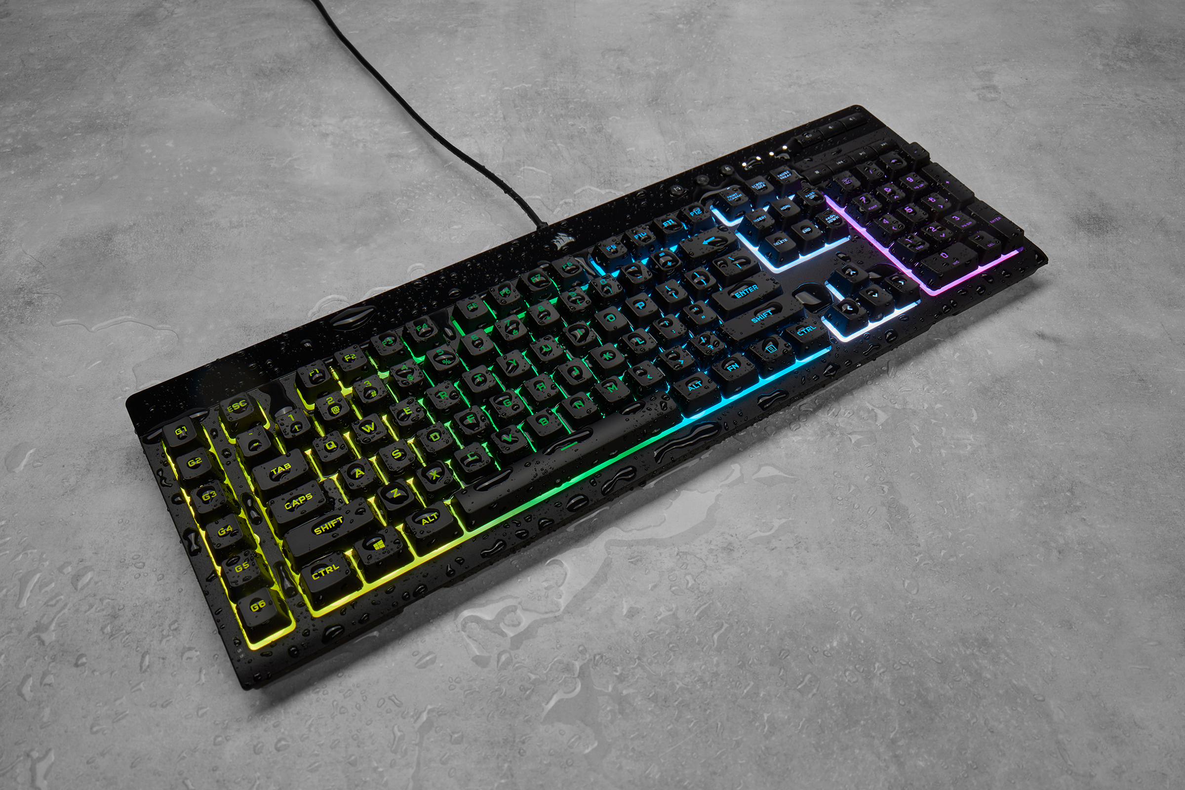 Un clavier noir avec des lumières colorées sur une surface grise.