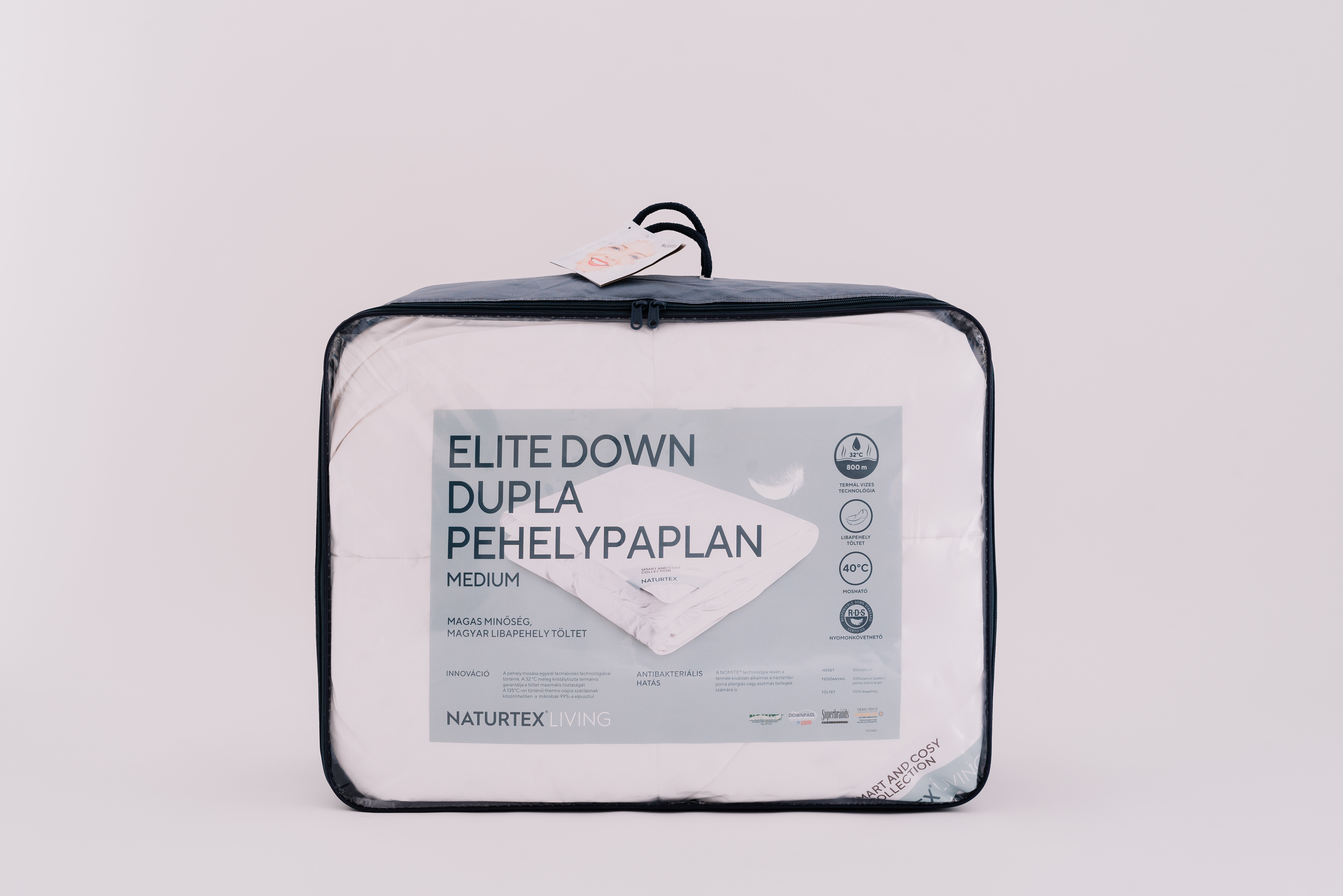 Táska fehér paplannal. A táskán a szöveg: 'Elite Down' és 'Medium'.
