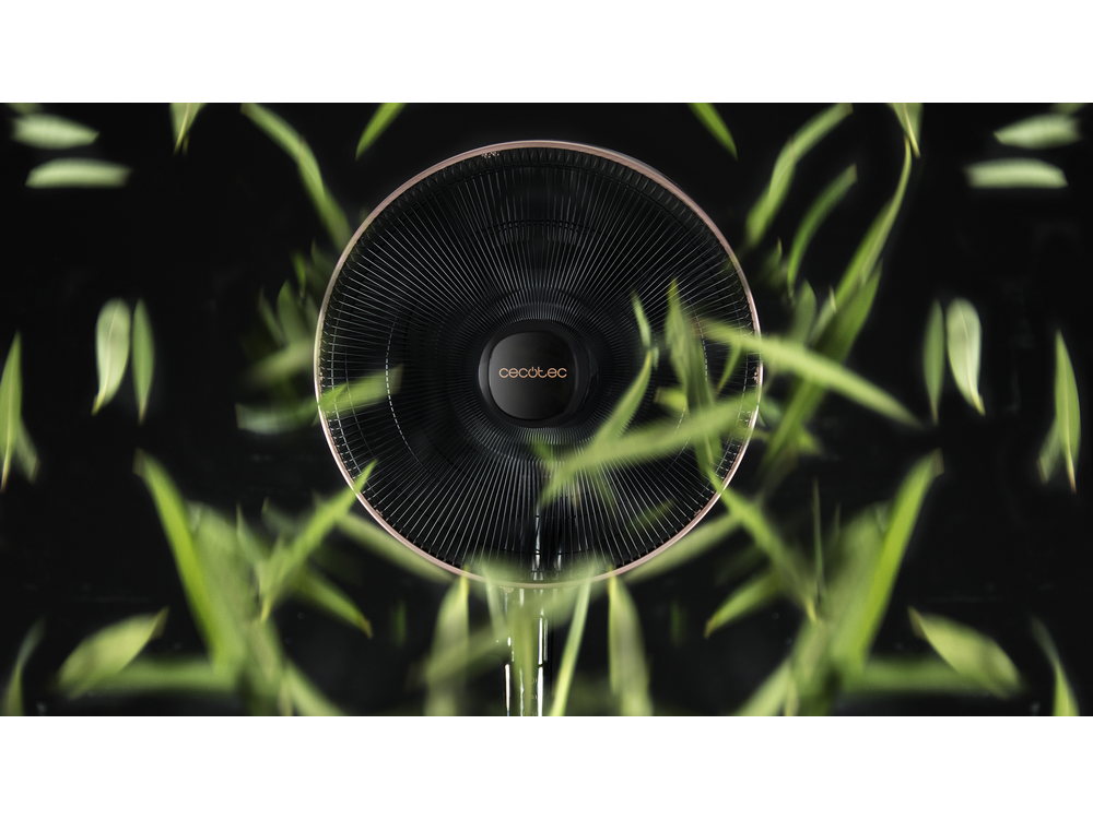 Un ventilador negro con diseño circular, rodeado de hojas verdes y un fondo negro.