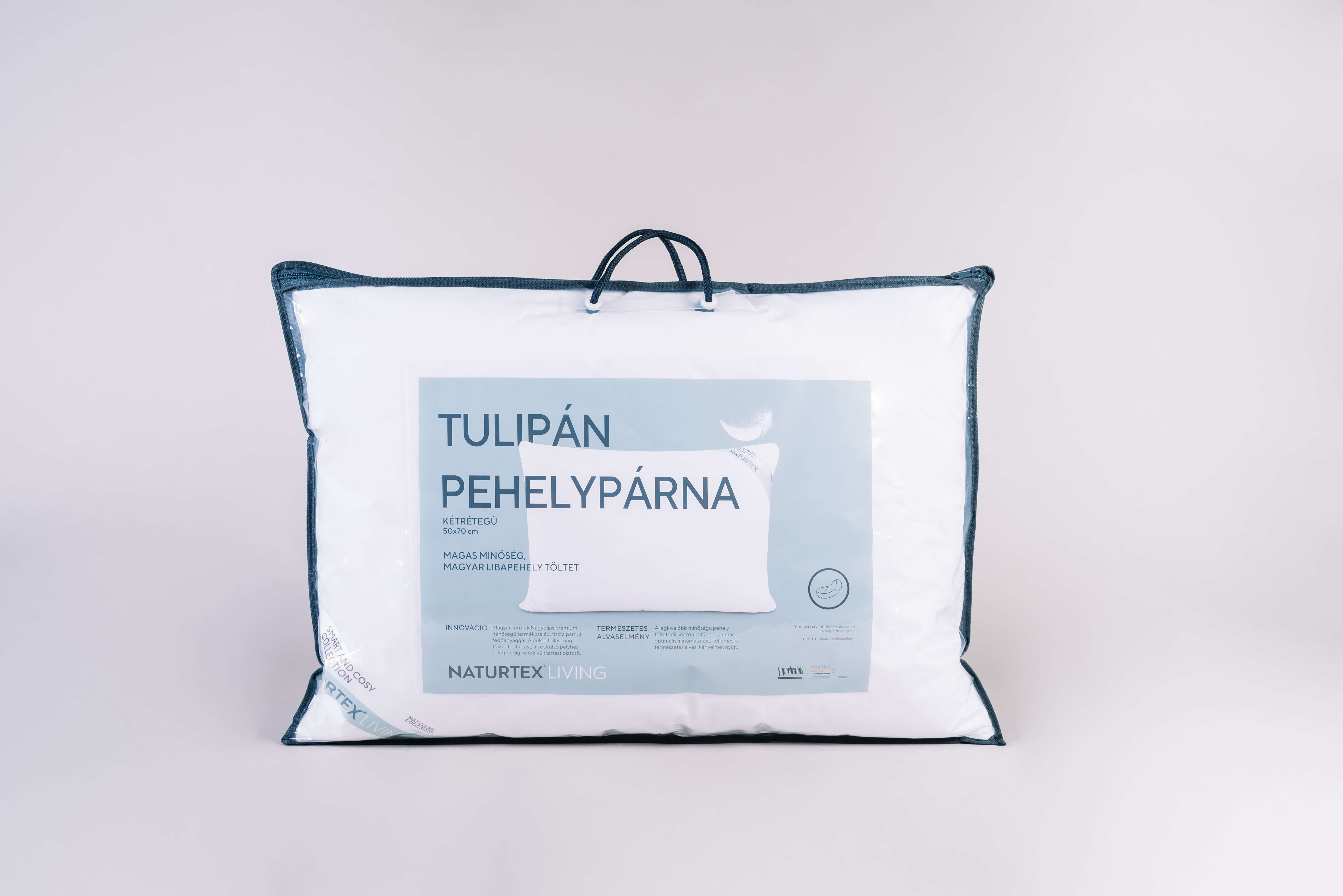 Párna műanyag zacskóban felirattal, fehér és kék márkajelzéssel, fehér háttérrel.