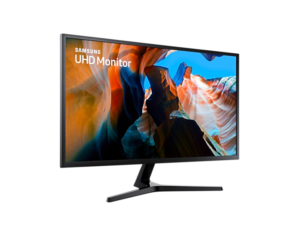 Monitor Samsung UHD sobre un soporte negro, con imagen de formaciones rocosas rojas.
