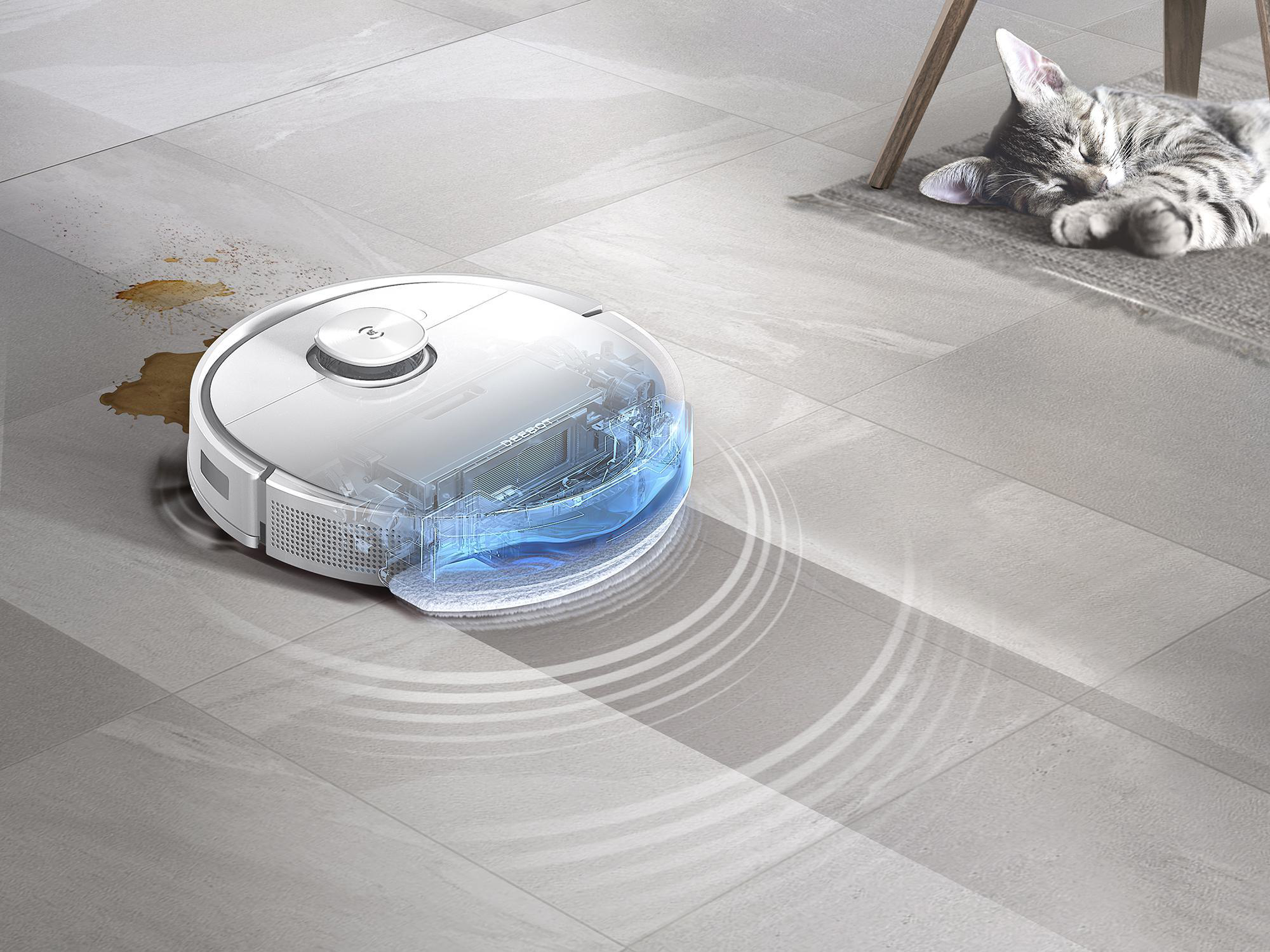 Roboter-Staubsauger auf dem Boden mit Wasserdarstellung; Katze schläft im Hintergrund.