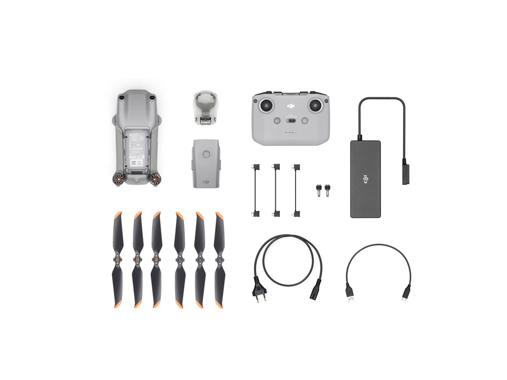 Piezas y accesorios de drones DJI extendidos sobre un fondo blanco.