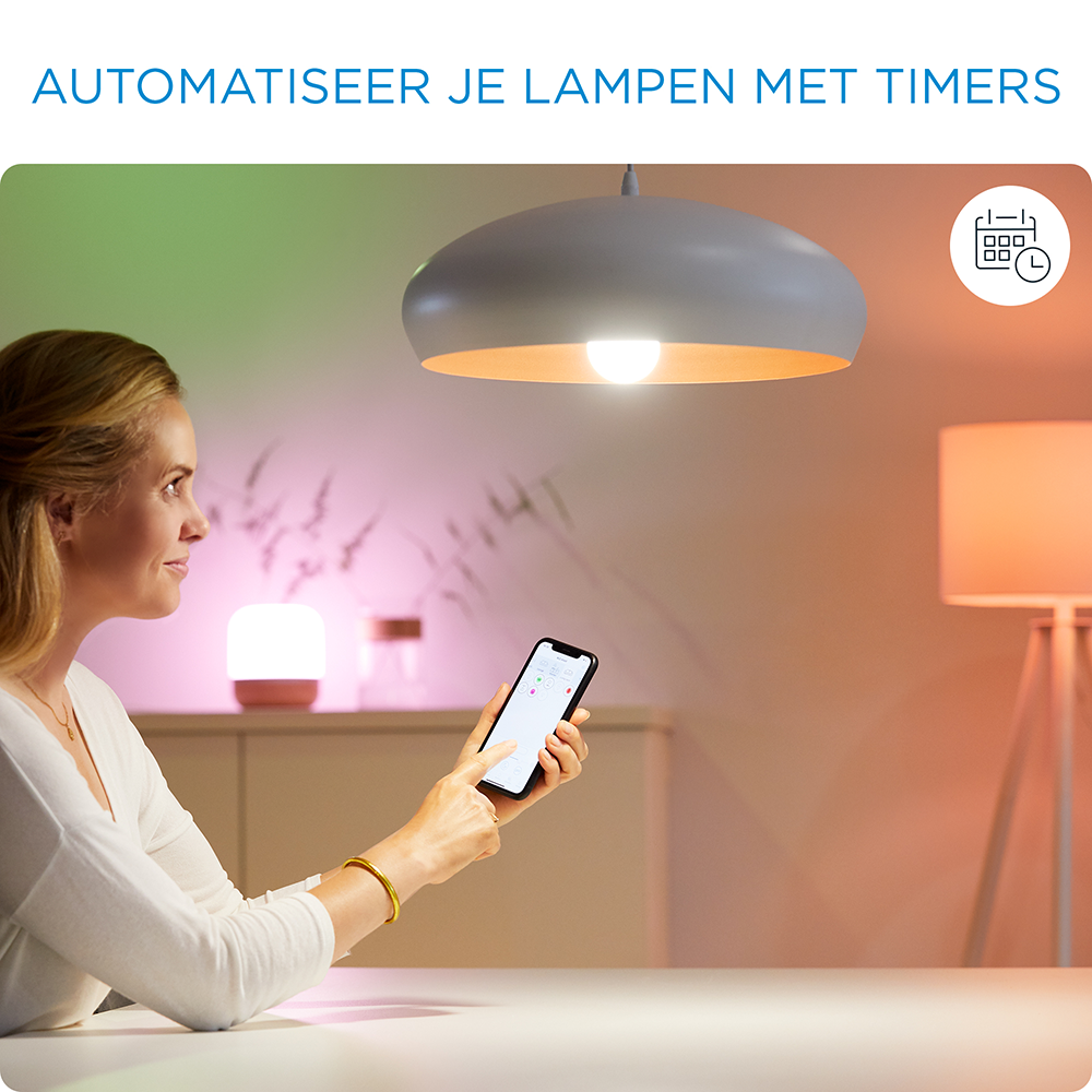 Woman using a smartphone to control smart lights in a living room with a lamp.
