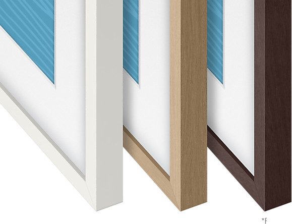 Trois cadres photo, blanc, bois et marron. Chaque cadre a un passe-partout blanc et un motif bleu.
