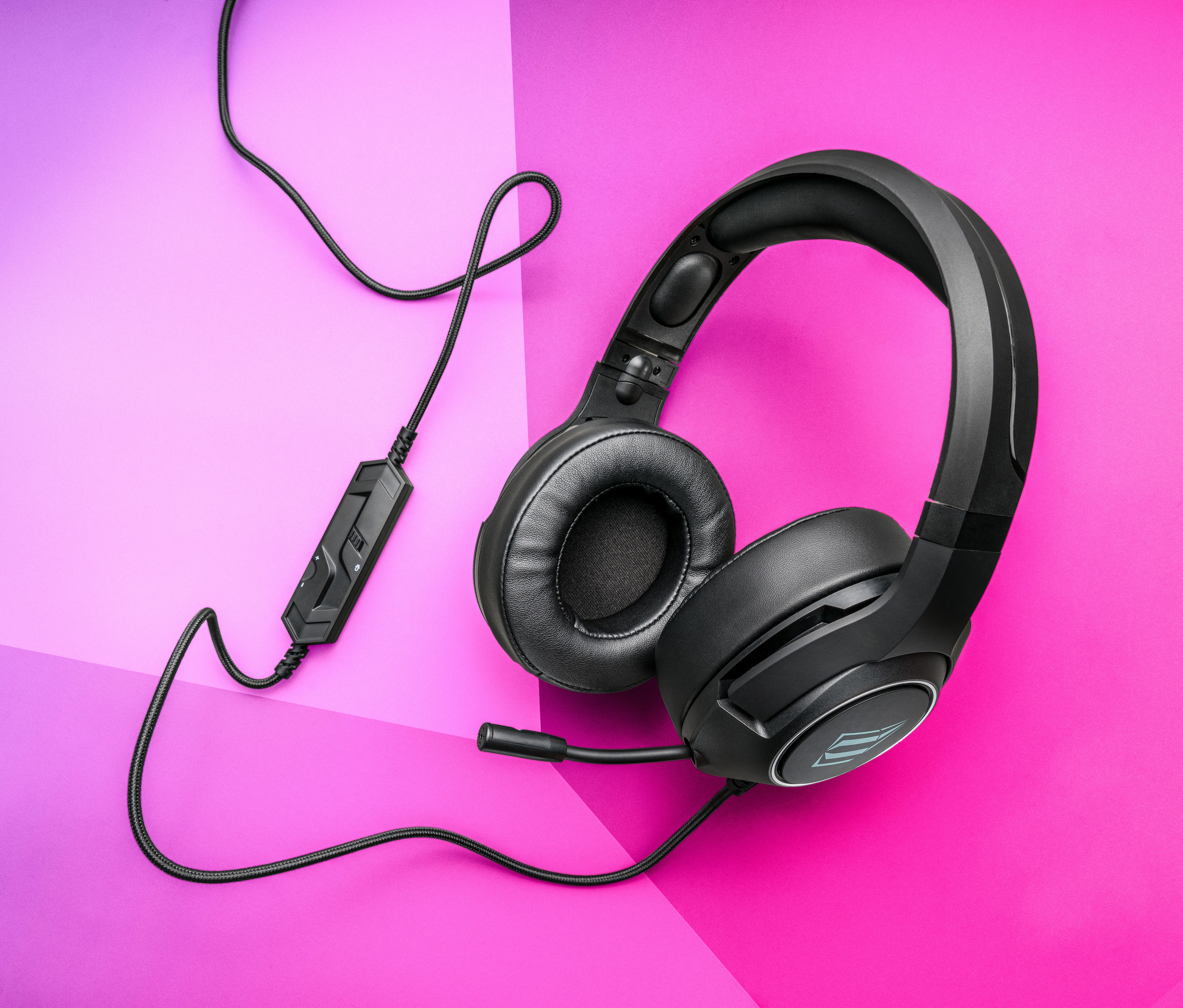 Schwarzes Gaming-Headset mit Mikrofon auf rosa-violettem Hintergrund.