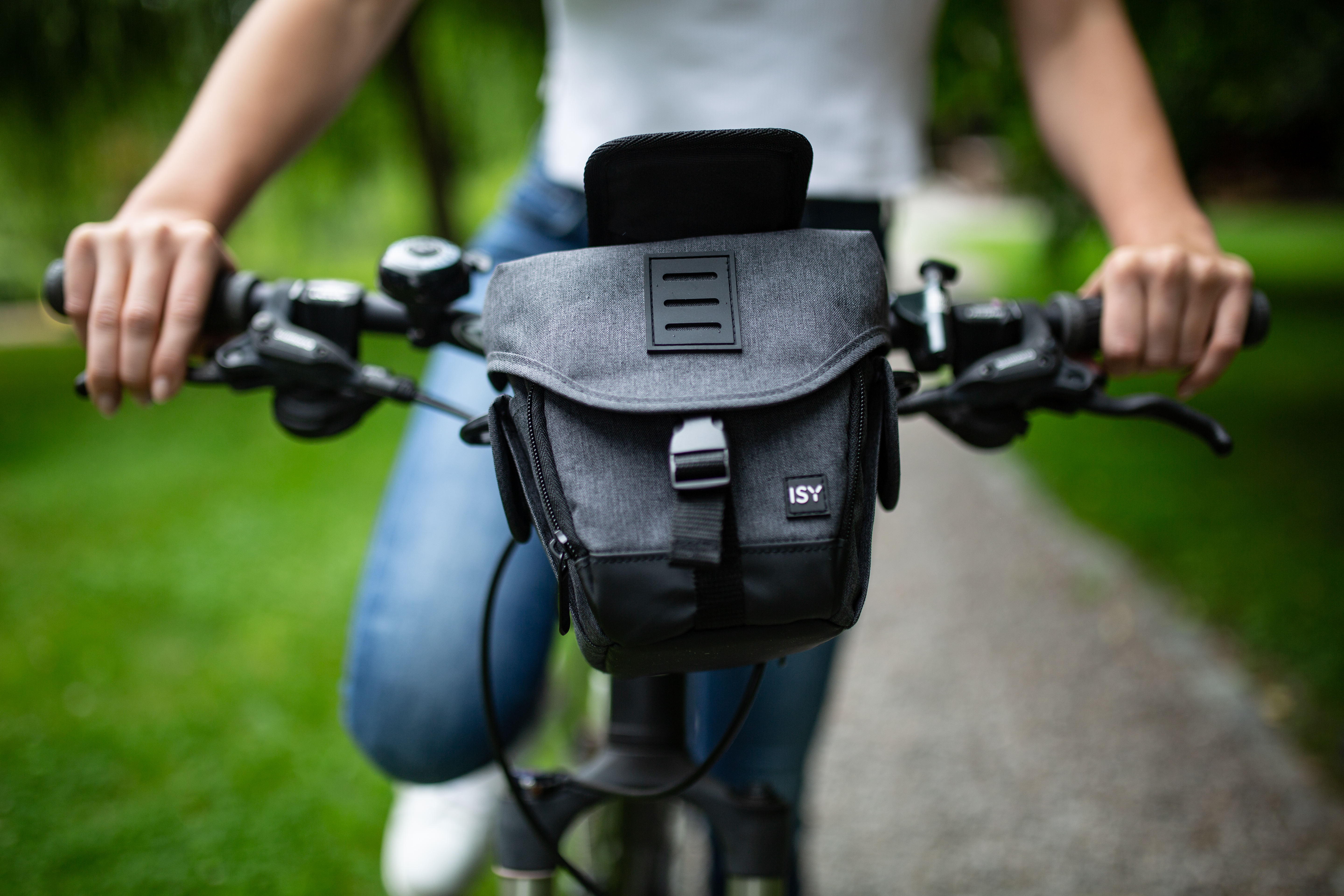 Hände einer Person halten Fahrradlenker mit einer daran befestigten Lenkertasche.