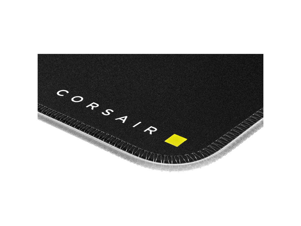 Primer plano de alfombrilla negra con costuras blancas y cuadrado amarillo, logo Corsair.