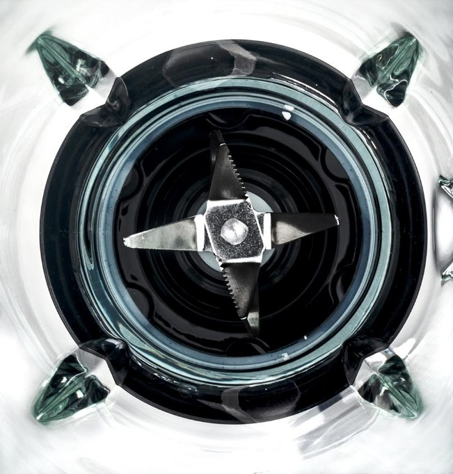 Close-up of a blender's blades, looking down into the glass container.