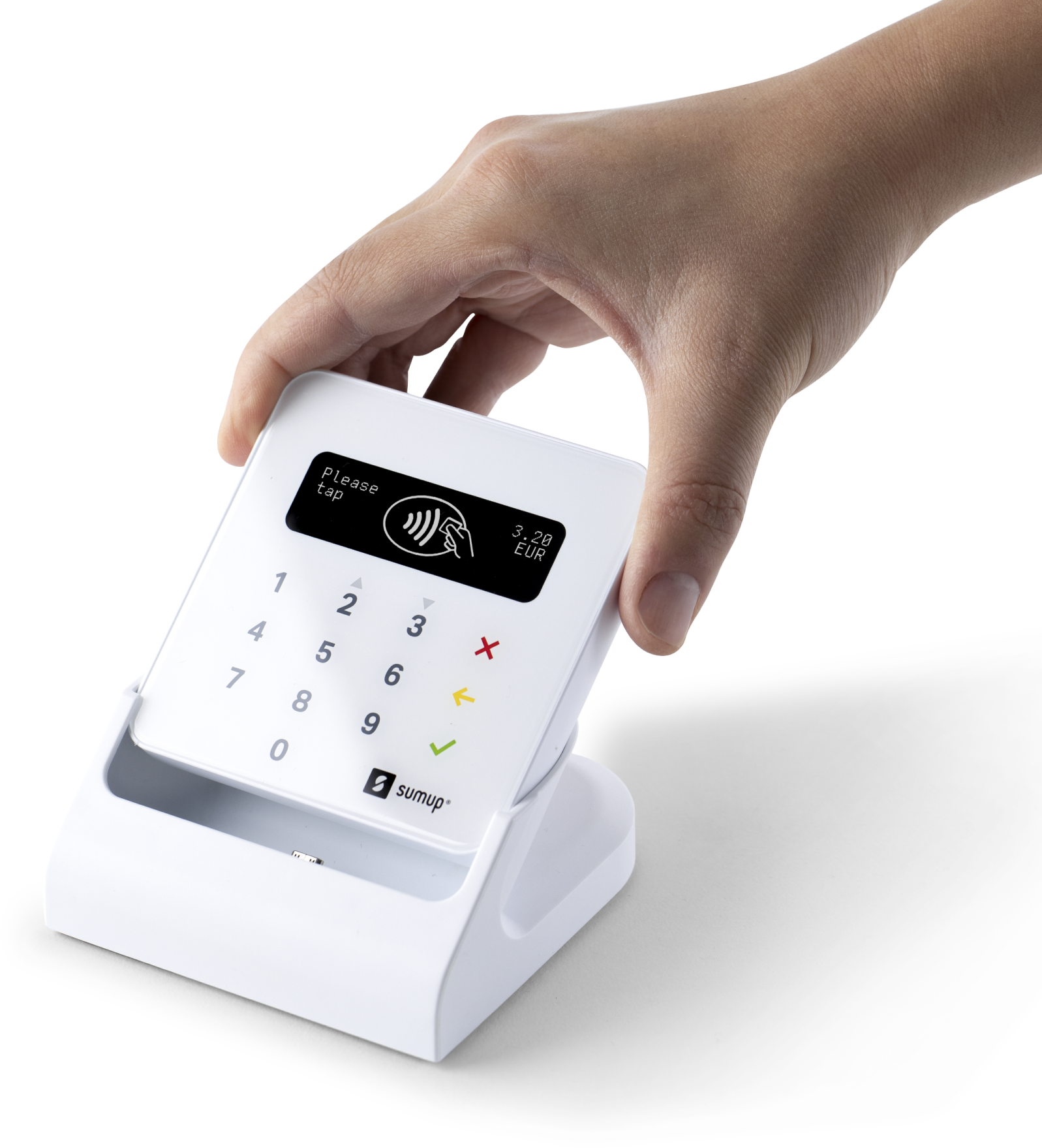 A hand holds a white SumUp card reader with a screen and keypad, on a white base.
