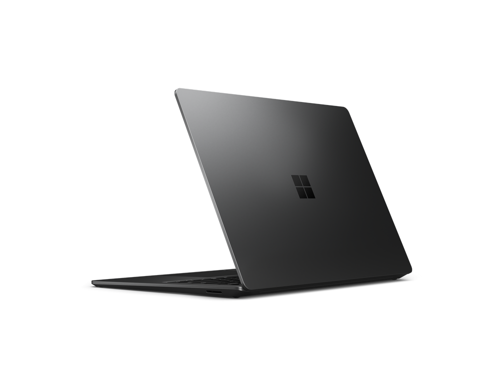 Portátil gris oscuro, ligeramente abierto, con el logotipo de Microsoft en la parte trasera, sobre fondo negro.