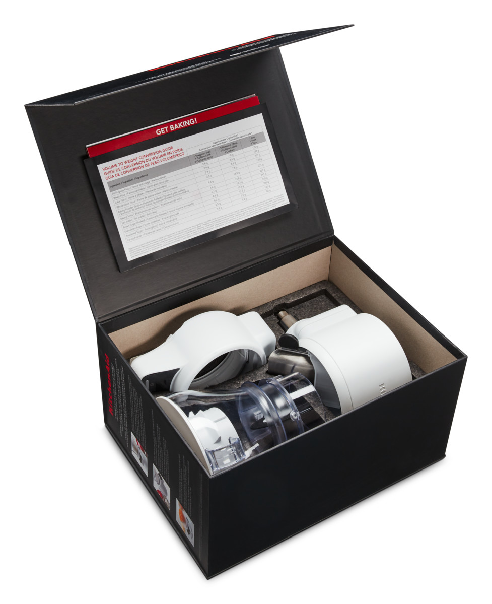 Eine schwarze Box mit weißen Küchengeräten und einer Gewichts-Umrechnungstabelle.