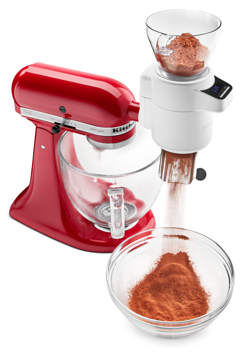 Roter KitchenAid-Küchenmixer mit Mahlwerkaufsatz, der in eine Glasschüssel mahlt.