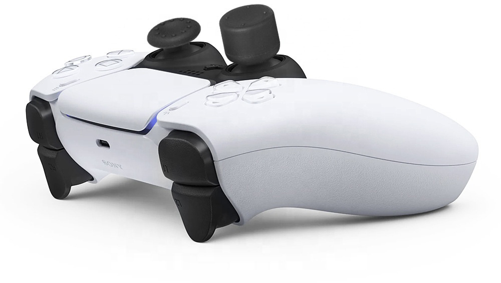 A white PlayStation 5 controller, with black joysticks, angled slightly to the left.