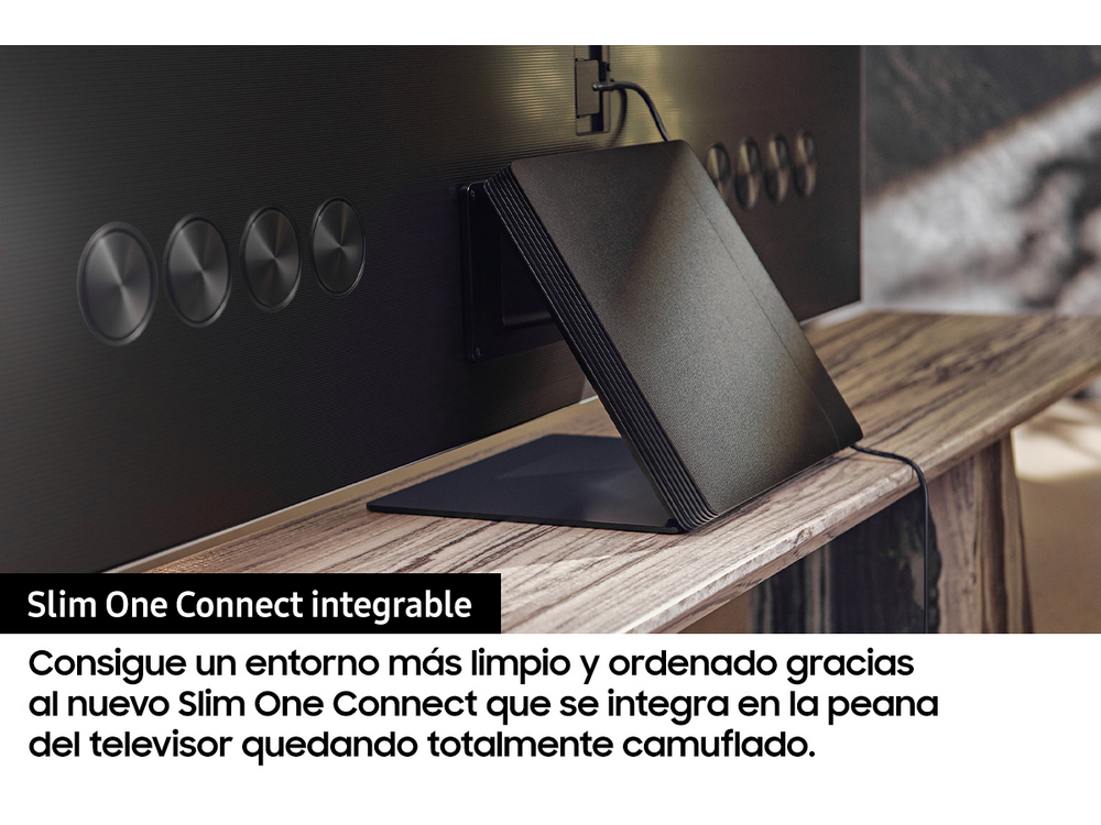 La parte posterior de un televisor negro con una caja Slim One Connect en una superficie de madera. Texto en español.