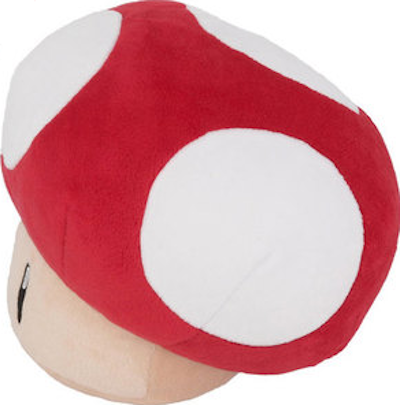 Un grand jouet en peluche en forme de champignon. Chapeau rouge à pois blancs, pied beige et herbe verte.