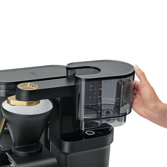 Main de femme remplissant une cafetière.