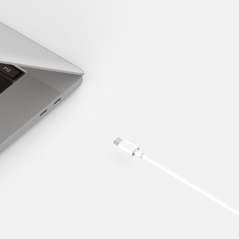 Egy laptop fehér USB-C kábellel csatlakoztatva.