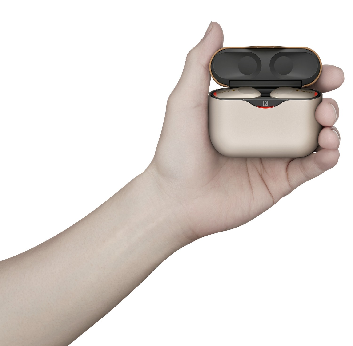 Una mano sosteniendo un estuche abierto de auriculares inalámbricos. Los auriculares son beige y negros.