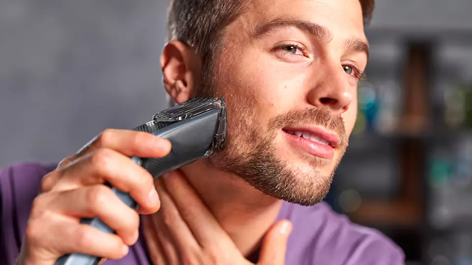 A man shaving his beard with a trimmer. Close-up shot.