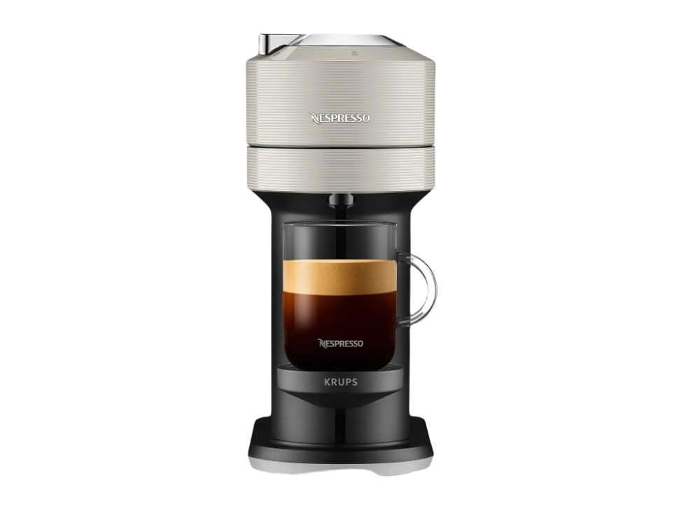 Una cafetera Nespresso con una taza de vidrio transparente, llena de café.