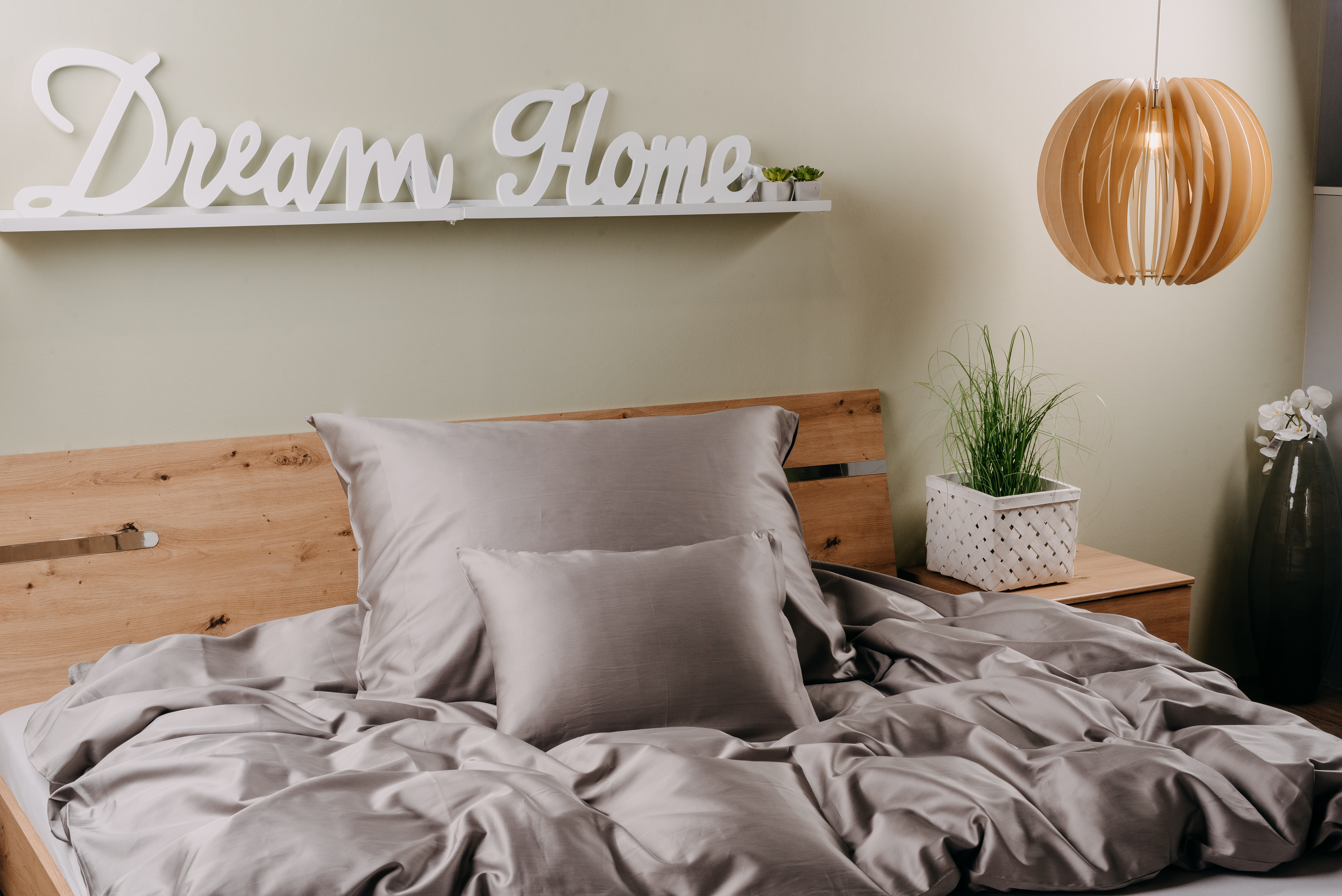 Hálószoba jelenet ággyal, párnákkal és egy "Dream Home" felirattal. Dekoratív elemek.