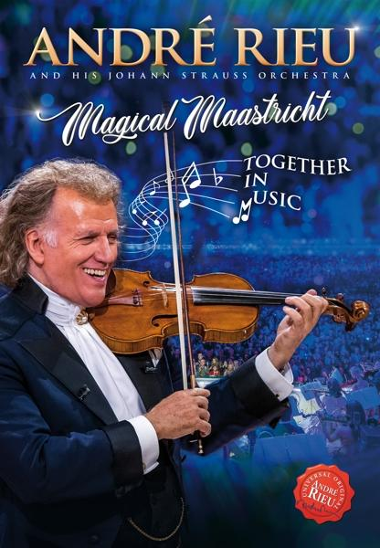 André Rieu, met viool, glimlacht. Achtergrond is een concert met publiek.