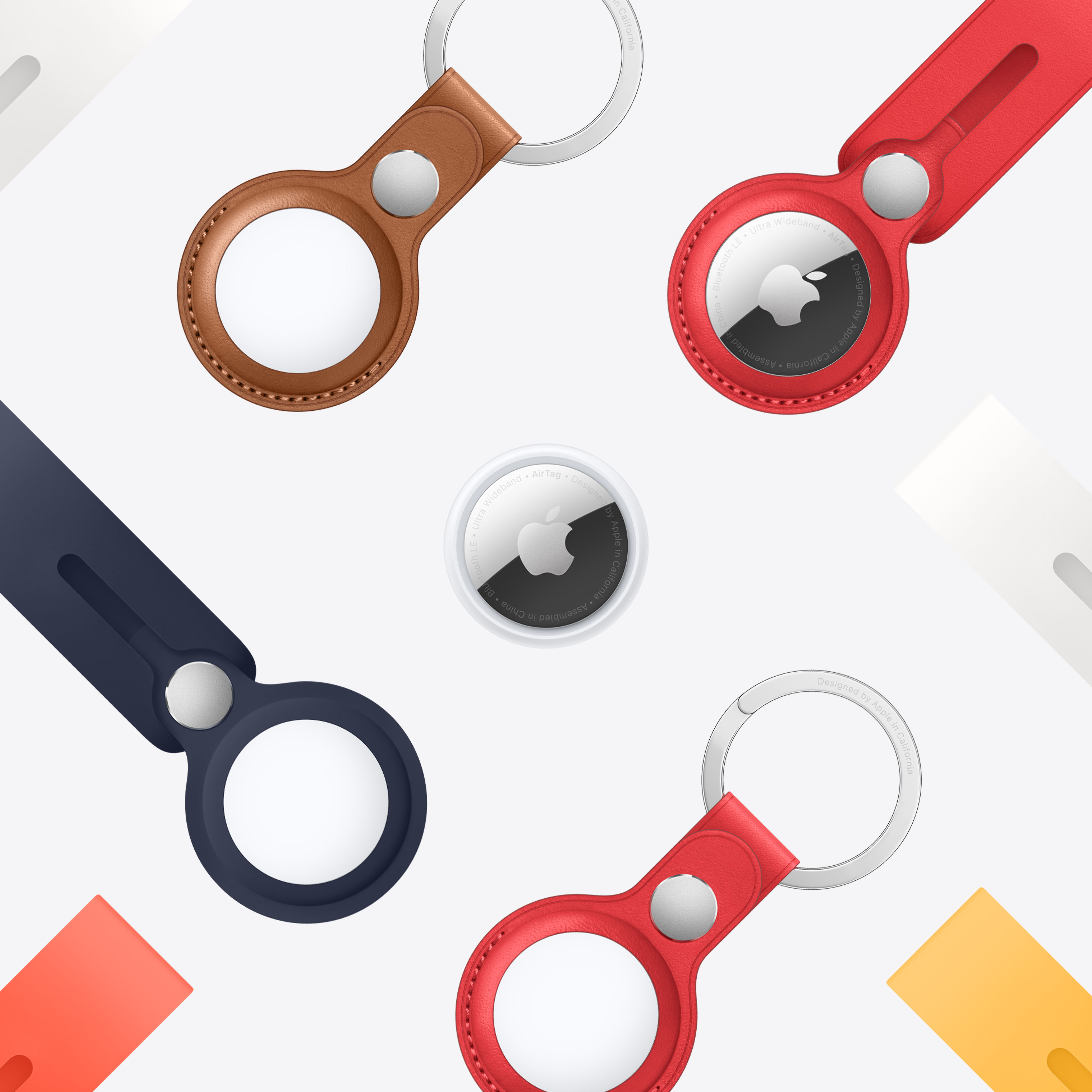 Cuatro Apple AirTags con correas de cuero y silicona, en varios colores, sobre blanco.