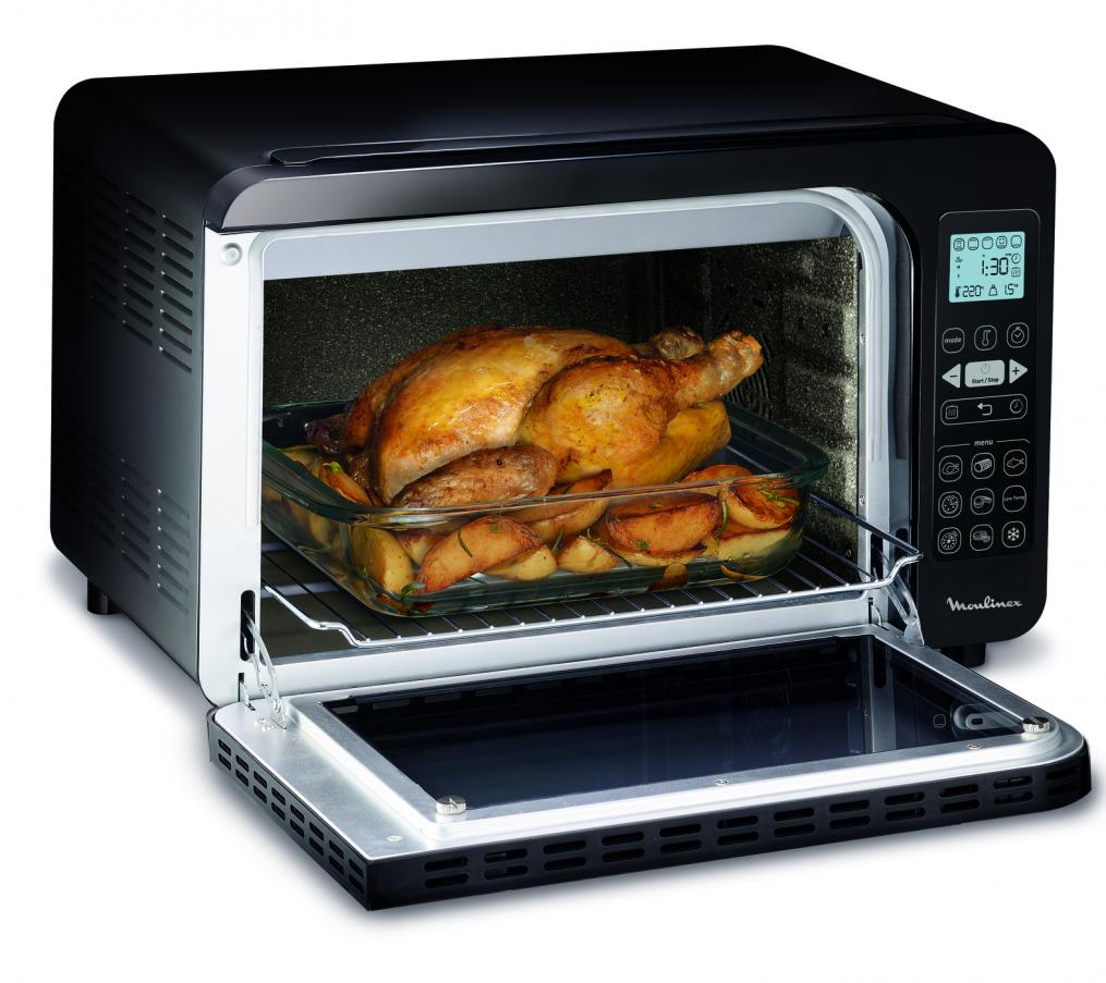 A black oven with a cooked chicken and potatoes inside a glass dish.