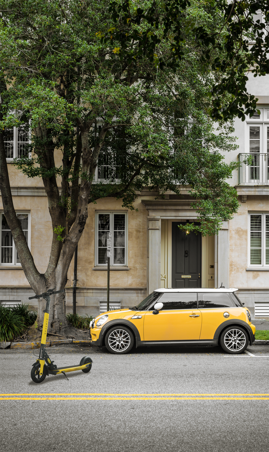 Gelber Mini Cooper parkt auf einer Straße. Ein Roller steht auf dem Bürgersteig daneben.