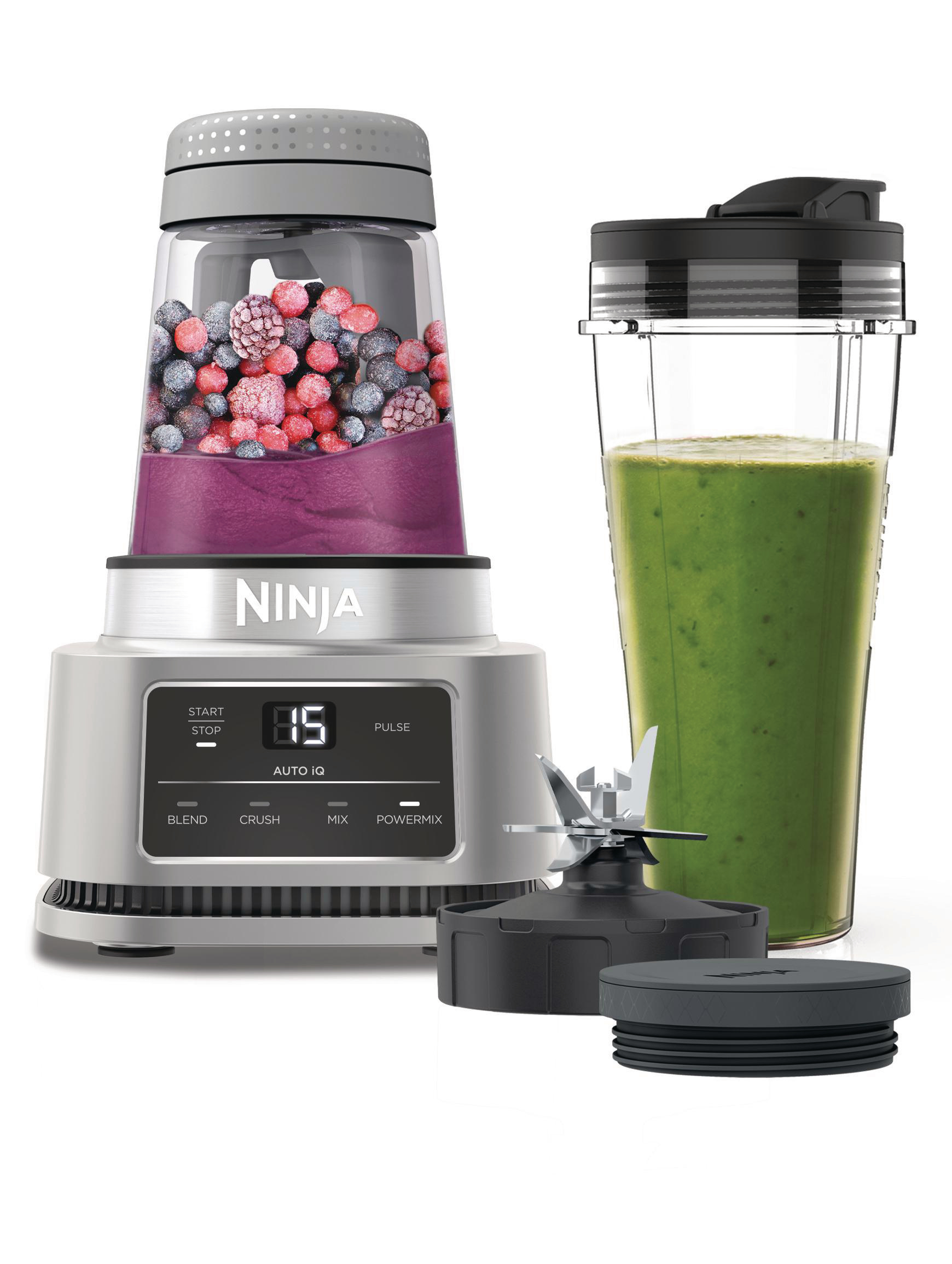 Ein Mixer mit einem Behälter mit gefrorenen Beeren und einem Smoothie.